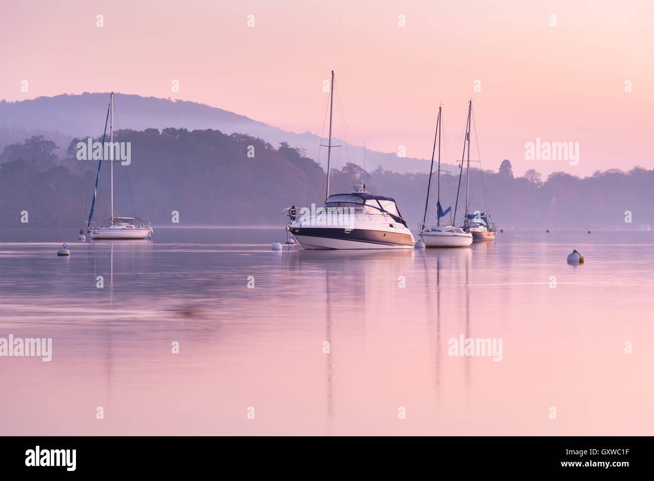 Boats moored on Lake Windermere at sunset, Bowness, Lake District, Cumbria, England. Autumn (November) 2015. Stock Photo