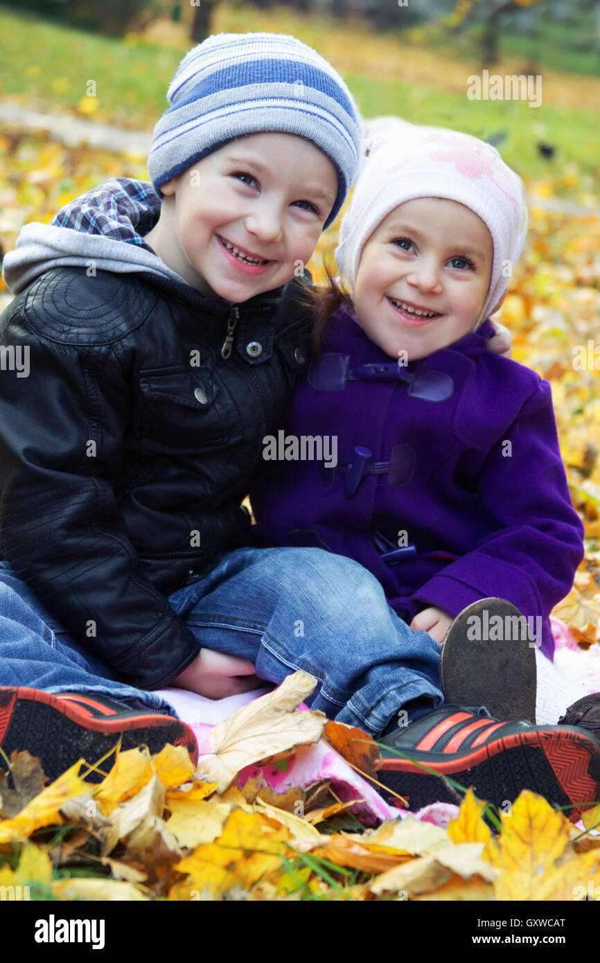 Sister and brother together on autumn leaves Stock Photo - Alamy
