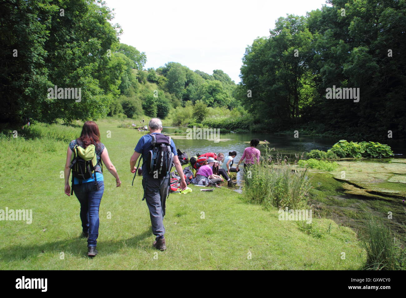 Walkers on a popular riverside route in Lathkiill Dale, a celebrated limestone dale in the Peak District, Derbyshire England UK Stock Photo