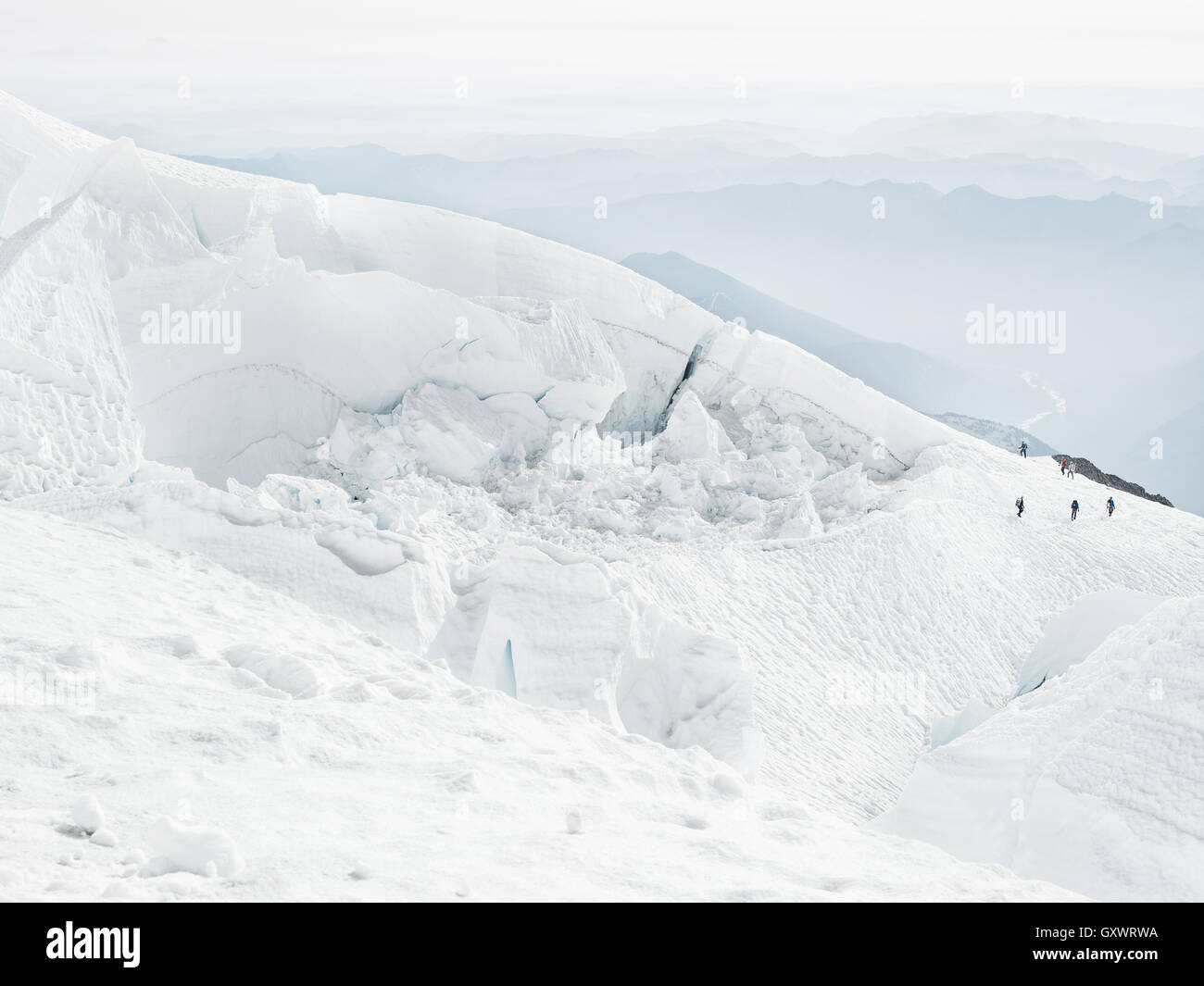 Trekkers make their way across the frozen earth on the journey Mt. Rainier's peak Stock Photo
