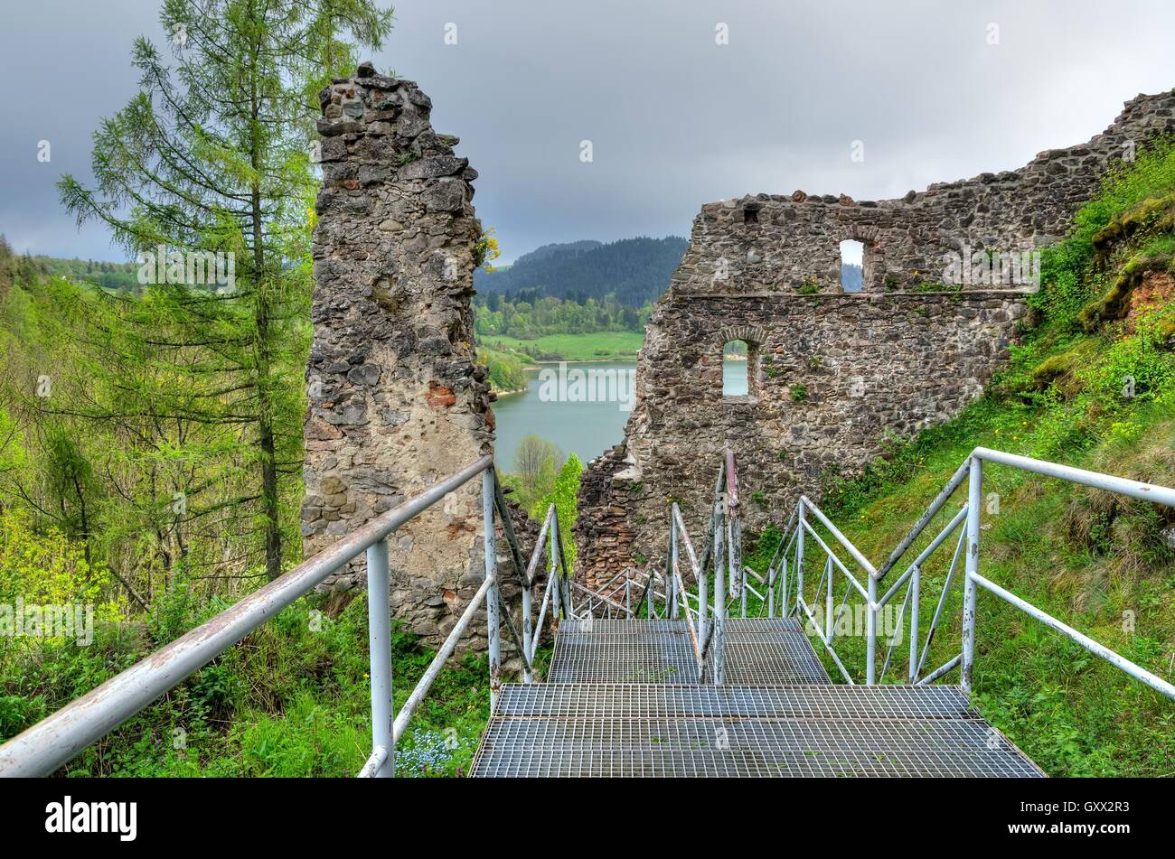 The ruins of the old castle with river  green hills in the background. Stock Photo