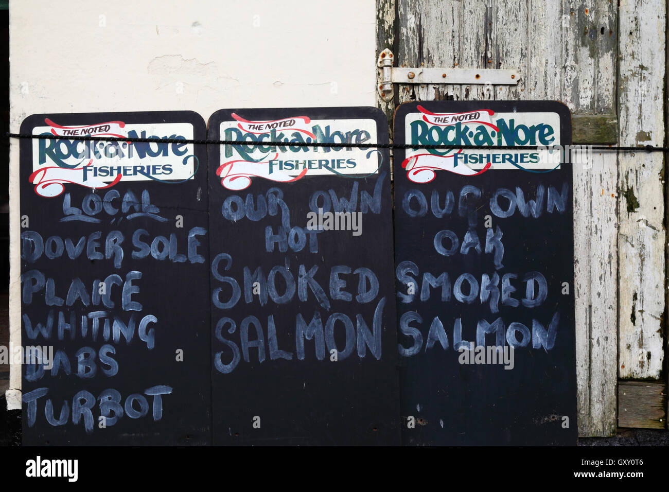Close up of signs advertising fresh fish and seafood outside shop at Rock-A-Nore, Old Town, Hastings, East Sussex, England, UK Stock Photo
