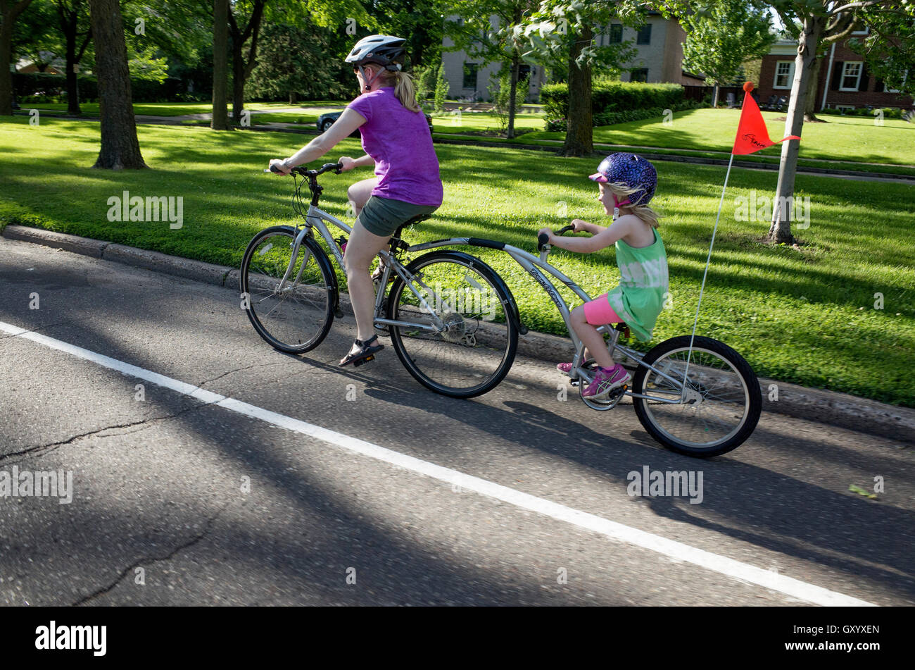 Mom and daughter ride tandem bicycle on Summit Avenue. St Paul