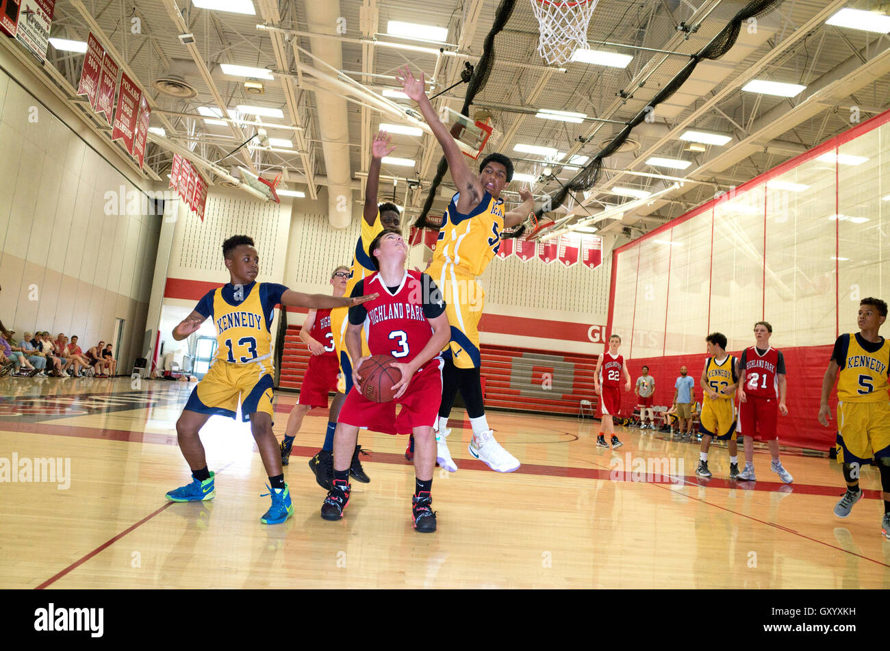 Black teen leaps to block shot in an exciting basketball game. North High School, White Bear Lake Minnesota MN USA Stock Photo