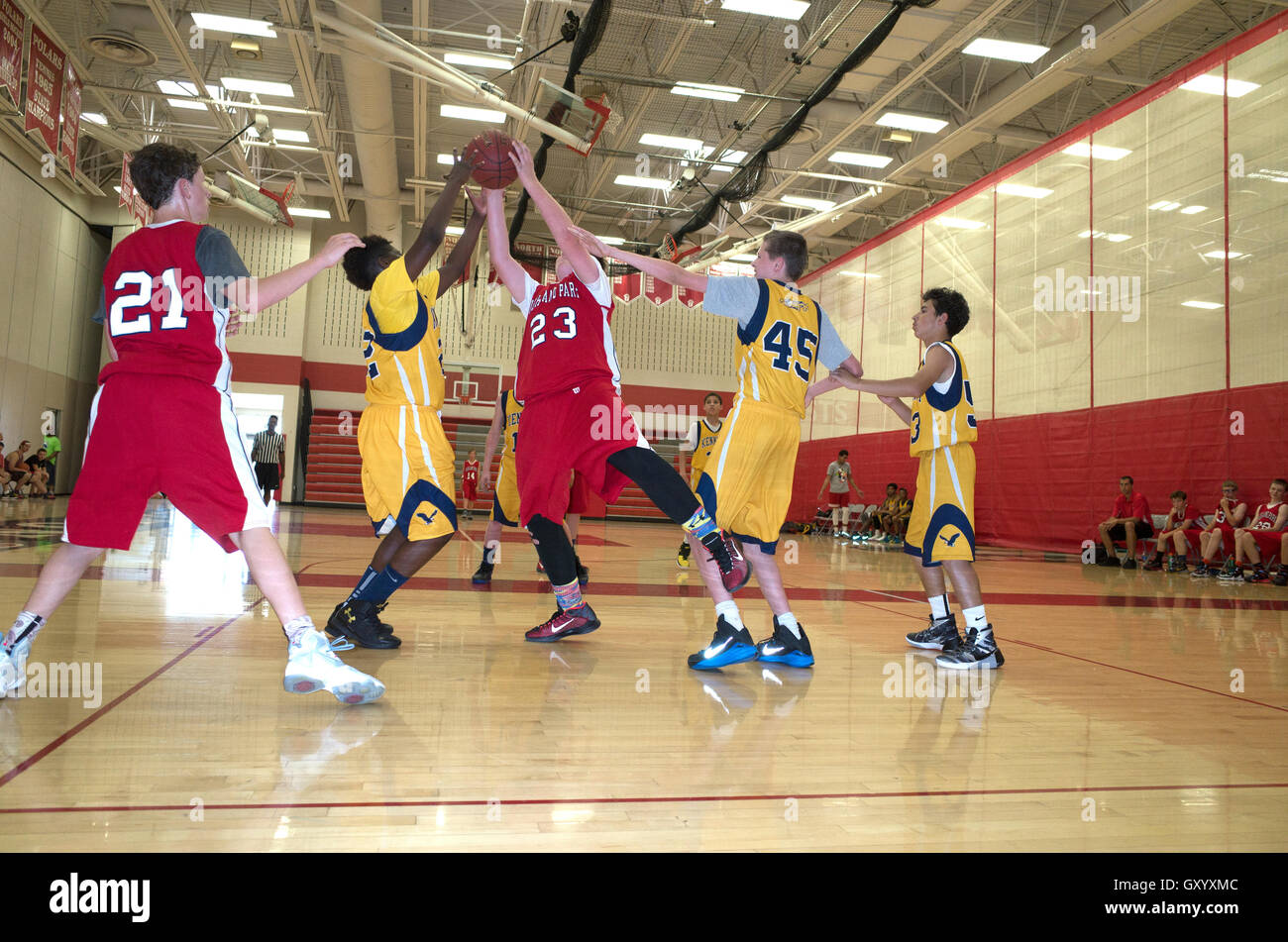 Black teen tries to block white basketball player from making layup. North High School, White Bear Lake Minnesota MN USA Stock Photo