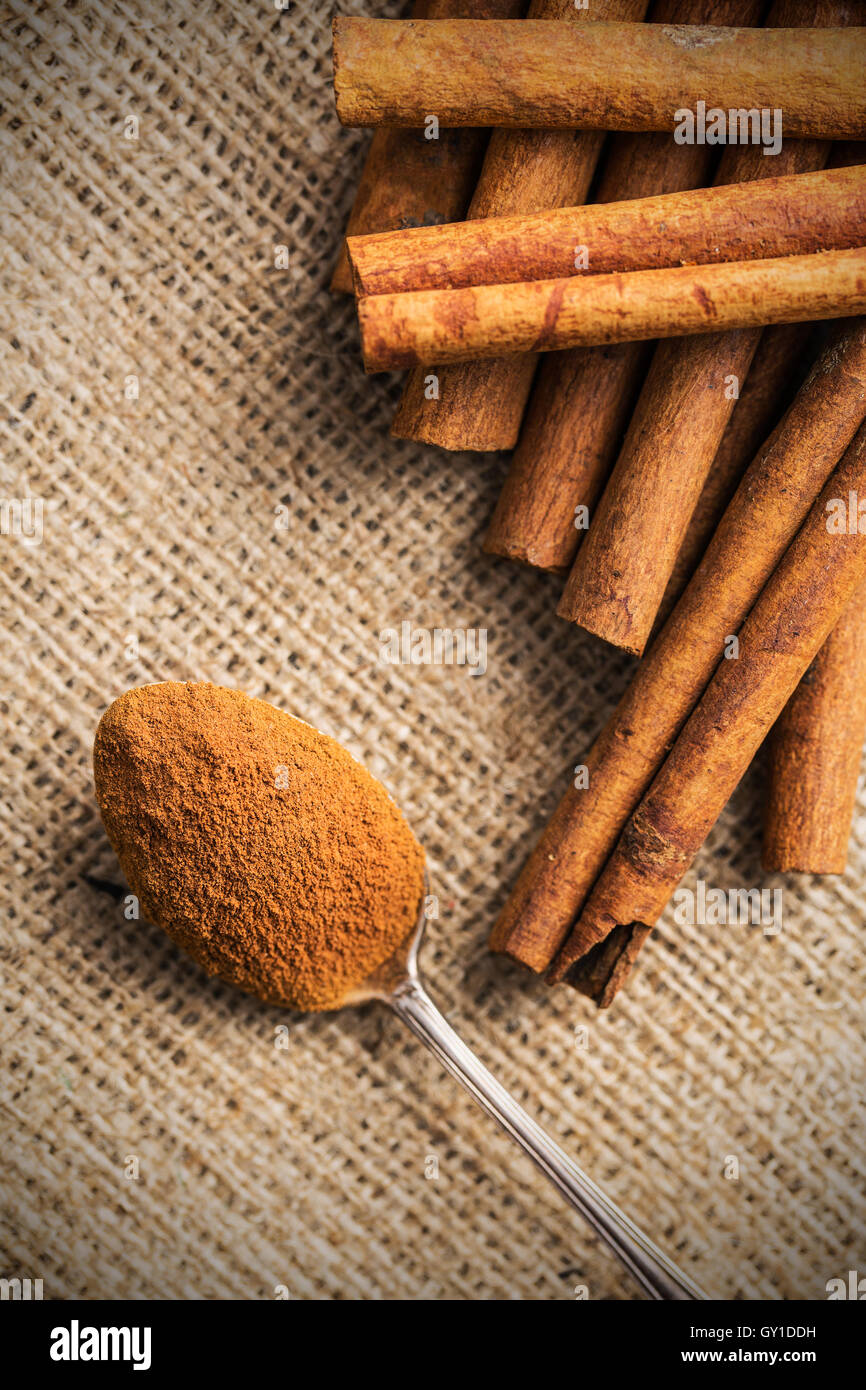 Cinnamon stick and ground cinnamon in spoon. Top view. Stock Photo