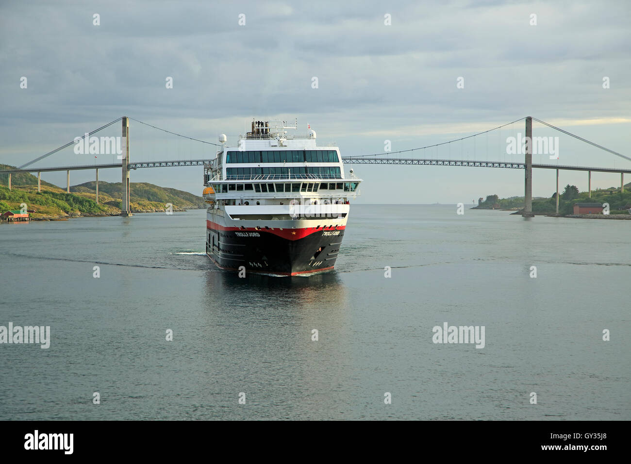 Hurtigruten ship 'Trollfjord' arriving at port of Rorvik, Norway with road bridge Stock Photo