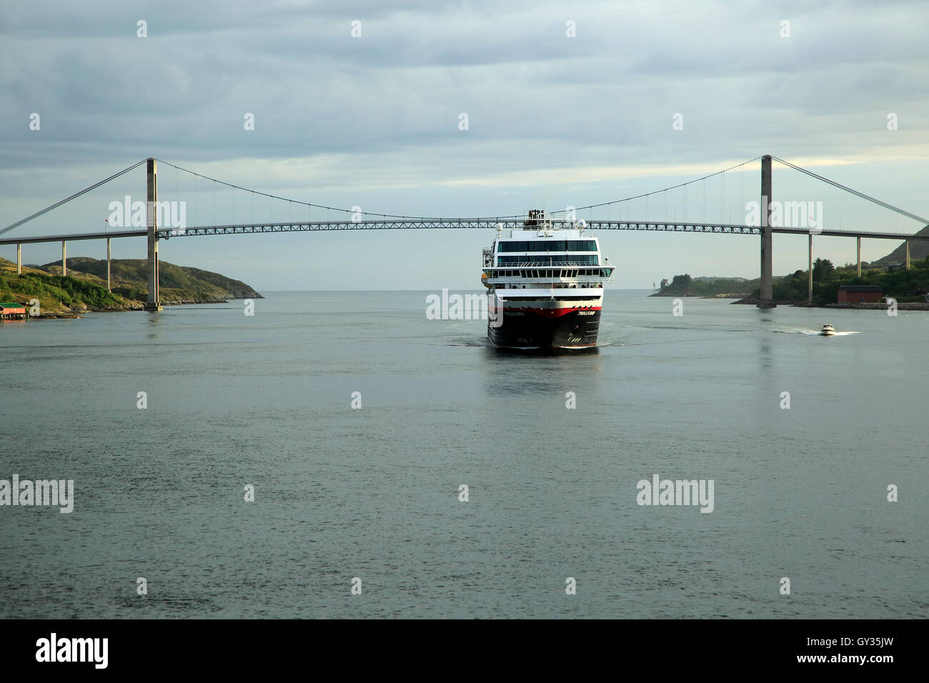 Hurtigruten ship 'Trollfjord' arriving at port of Rorvik, Norway with road bridge Stock Photo