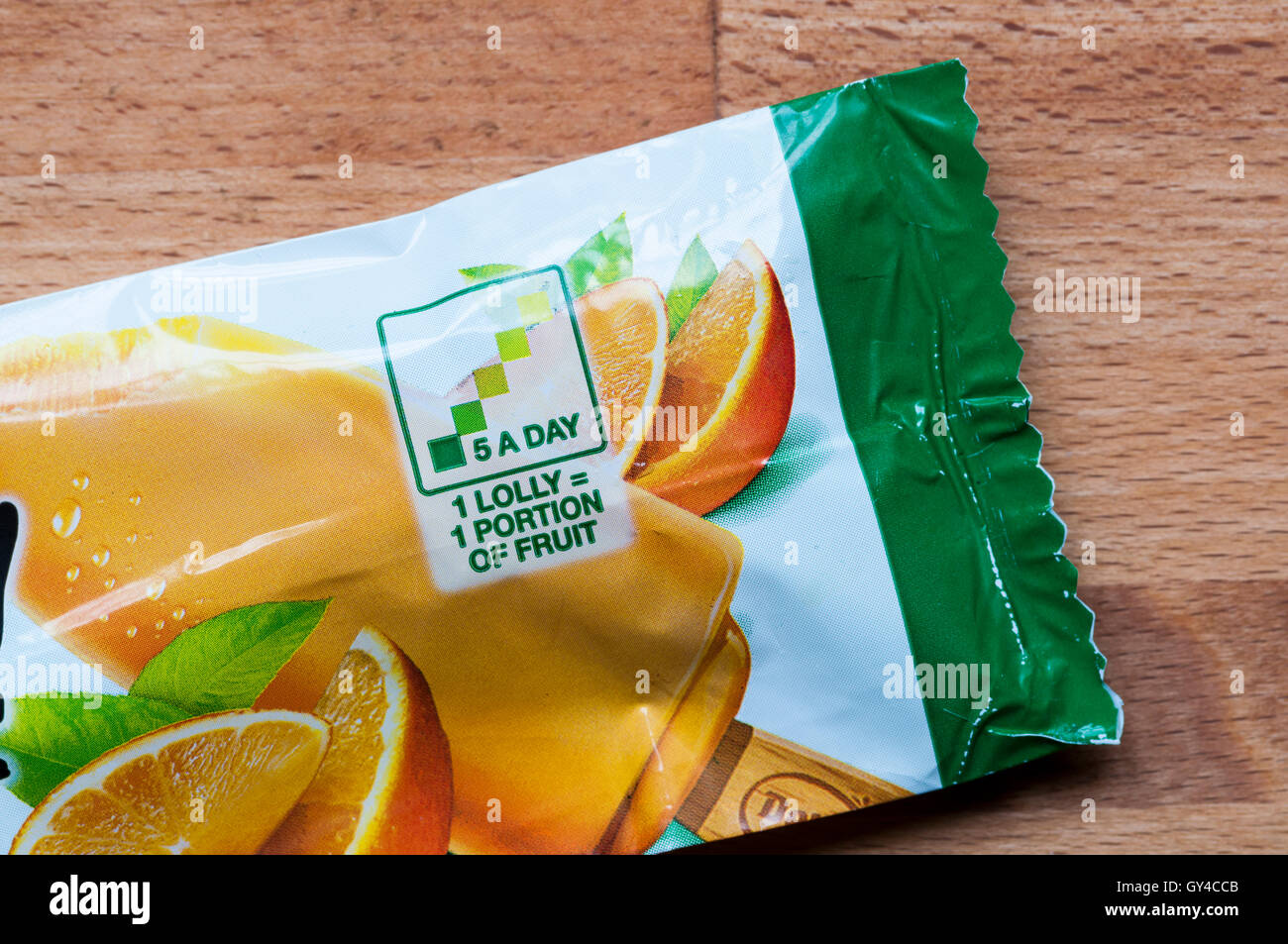 Wrapper of a Del Monte orange lolly says that 1 lolly equals 1 portion of fruit and is one of your 5 a day. Stock Photo