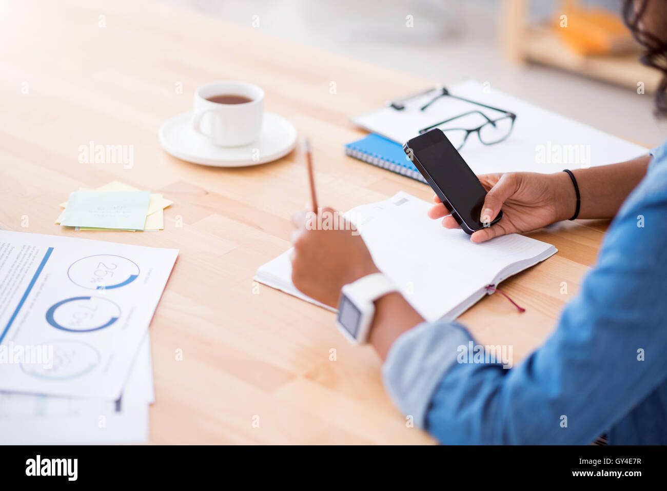 Pleasant woman sitting at the table Stock Photo - Alamy