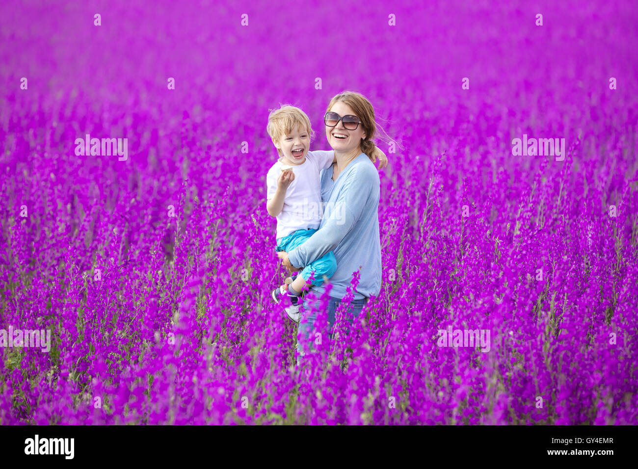 Young woman and her son having fun in purple field Stock Photo