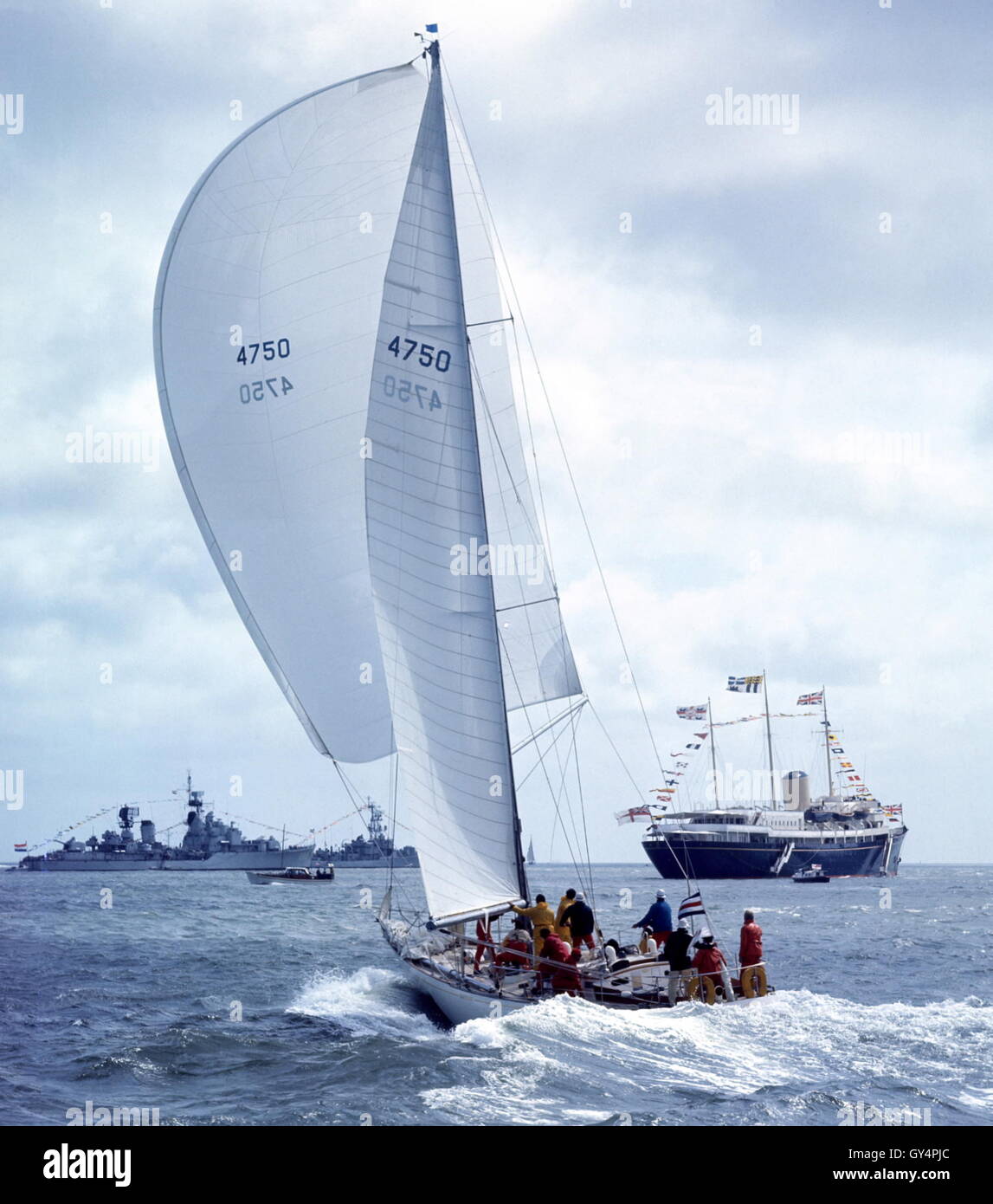 AJAX NEWS PHOTOS. 1971. SOLENT, ENGLAND. - ADMIRAL'S CUP - AMERICAN ENTRY YANKEE GIRL POWERS TOWARD COWES ROADS WITH THE ROYAL YACHT HMRY BRITANNIA AND NAVAL GUARDSHIPS IN BACKGROUND. PHOTO:JONATHAN EASTLAND/AJAX REF:C7105D6 2 Stock Photo