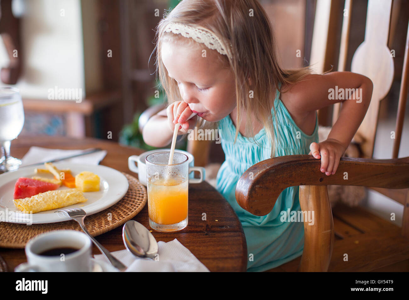 Breakfast Little Adorable little girl having breakfast and drinking fruit cocktail Stock ...