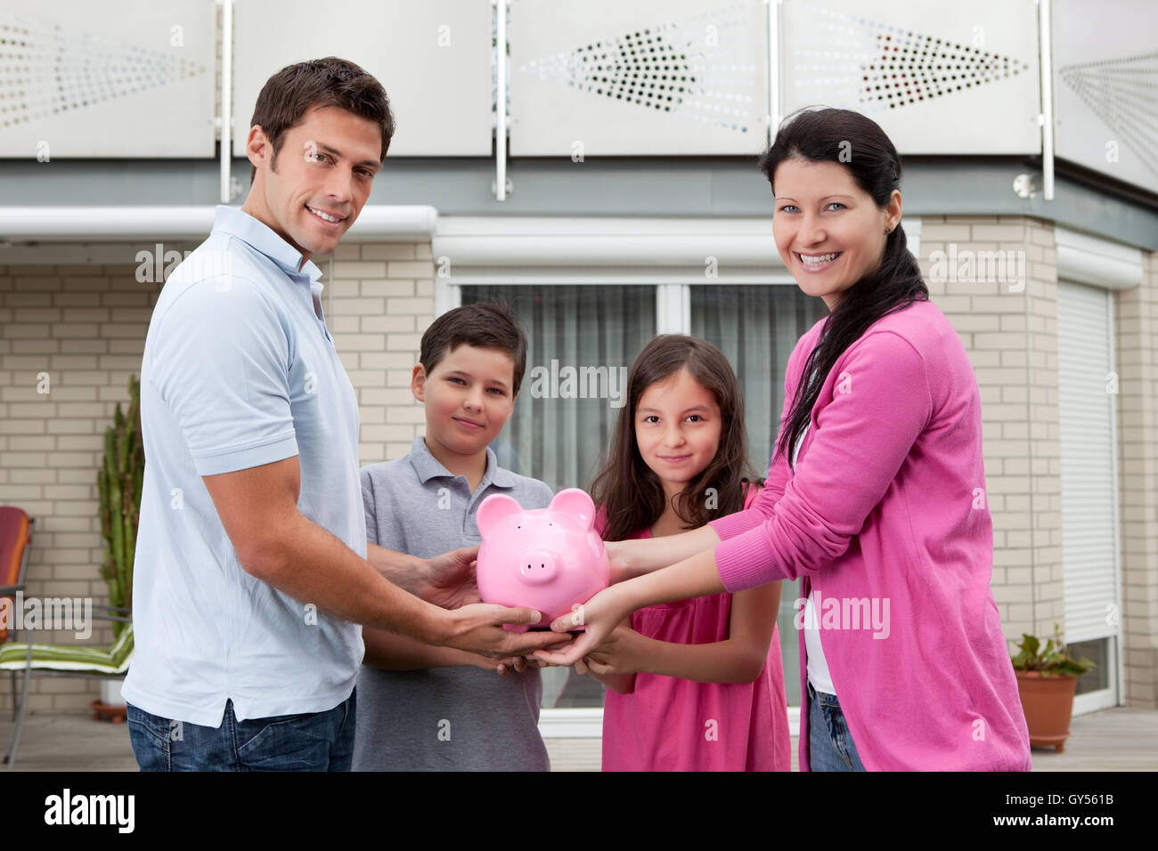 Savings concept - Happy family with piggy bank Stock Photo - Alamy