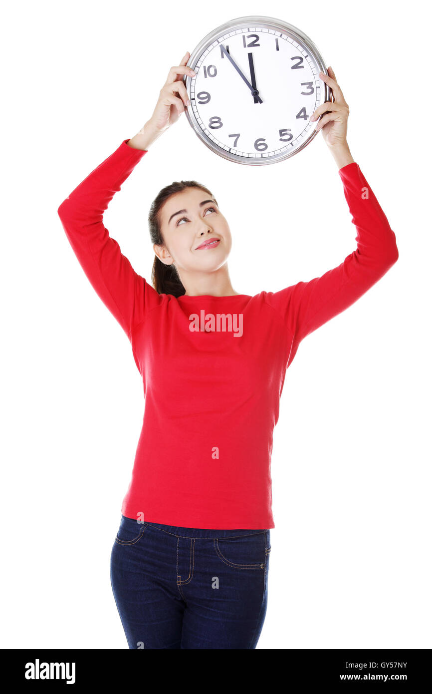 Attractive young woman holding a clock Stock Photo - Alamy