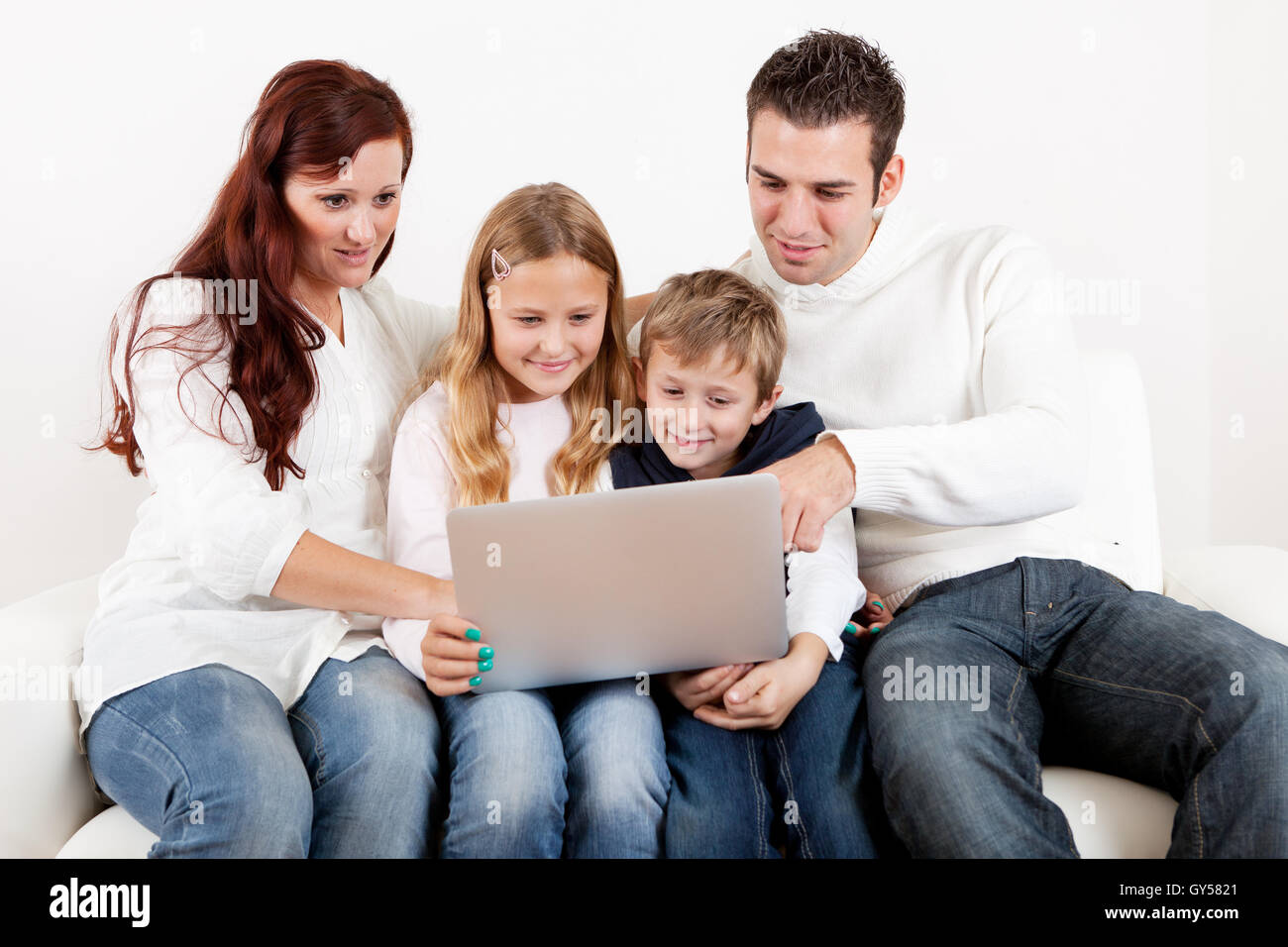 Happy family using laptop at home Stock Photo - Alamy