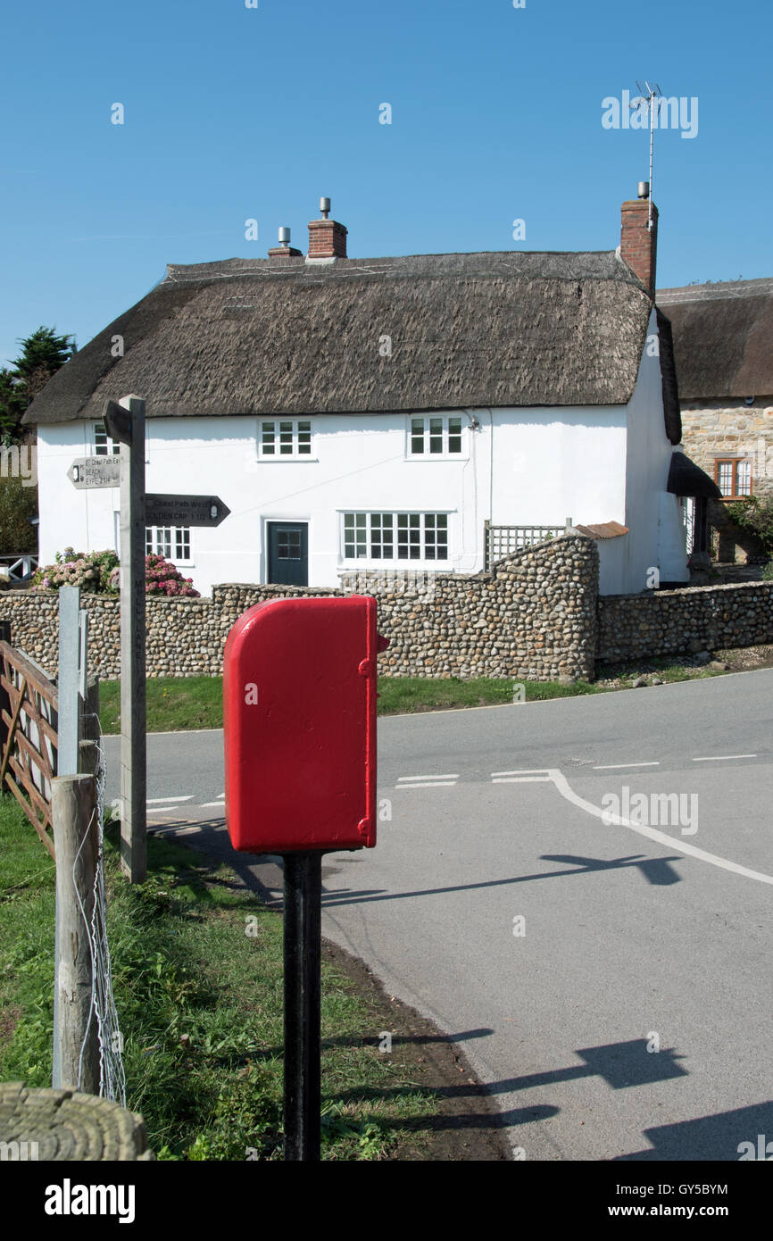 A red postbox, signpost and thatched cottage at Seatown, Dorset Stock Photo Alamy