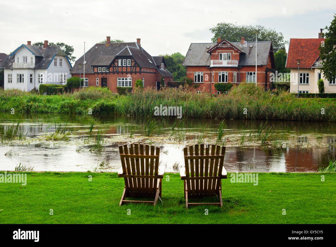 Two Wooden Armchairs Facing Ribe River, Denmark Stock Photo