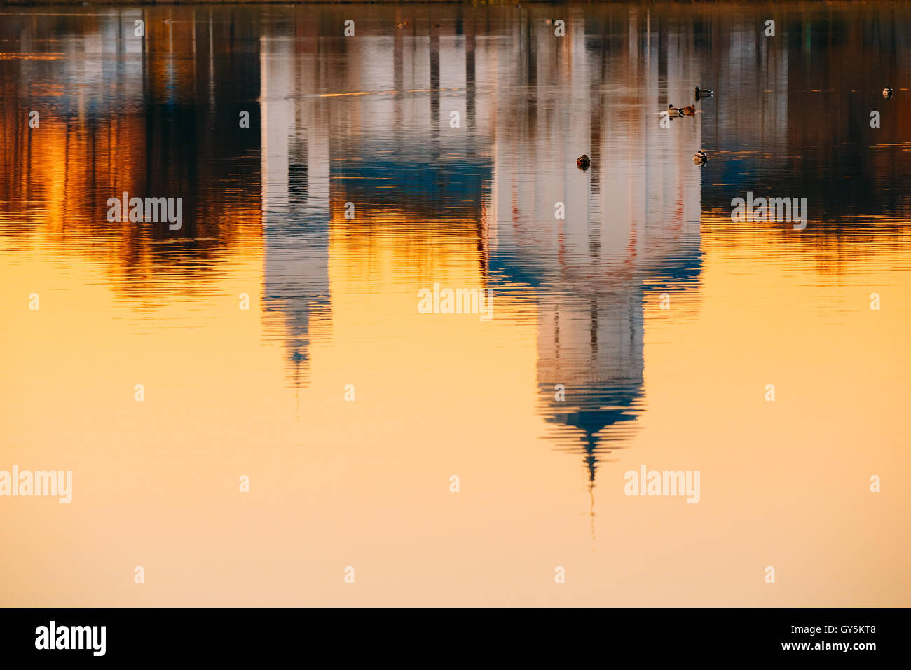 The Reflection Image Of Russian Orthodox Christian Temple Church Chapel On Sunset Sunrise Dawn River Lake Water Surface, Russia. Stock Photo