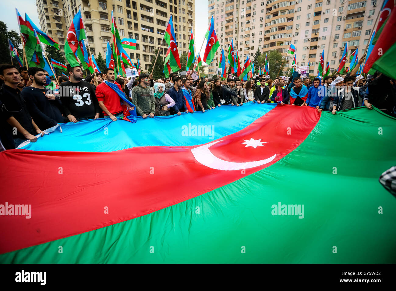 Baku, Azerbaijan. 17th Sep, 2016. Azerbaijani opposition supporter holds a big Azerbaijan flag during the rally in Baky at Mahsul stadium. Today hundreds of anti government protesters are holding a rally ahead of a key referendum. The protesters are demonstrating against a September 26 referendum scheduled in the tightly controlled South Caucasus country that is expected to strengthen the authority of President Ilham Aliyev, extend the length of presidential terms, and drop the minimum age for future presidential candidates. Credit:  Aziz Karimov/Pacific Press/Alamy Live News Stock Photo