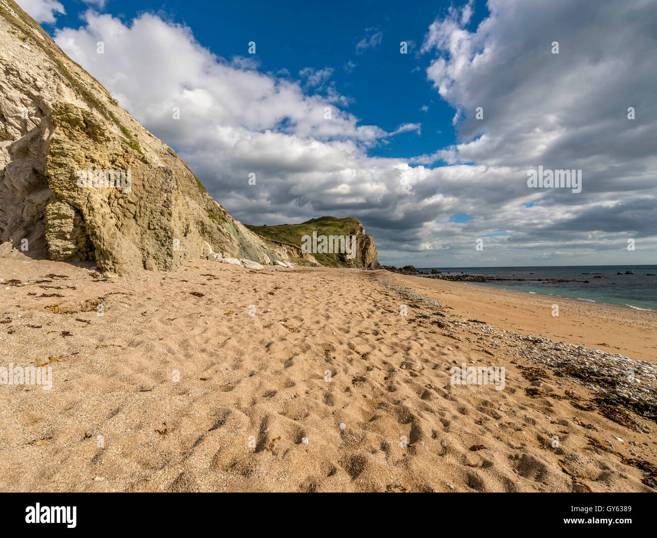 Landscape depicting the sandy Jurassic shoreline at Man O'War beach, St Oswald's Bay on a fine summer day. Stock Photo