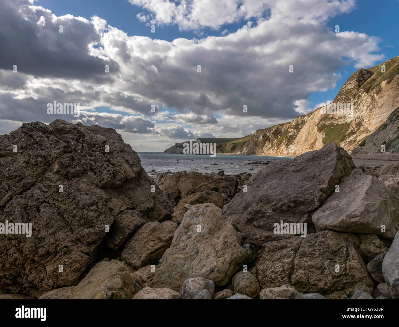 Landscape depicting the rocky shoreline of Man O'War beach on a fine summer day with Durdle Door headland in the background. Stock Photo