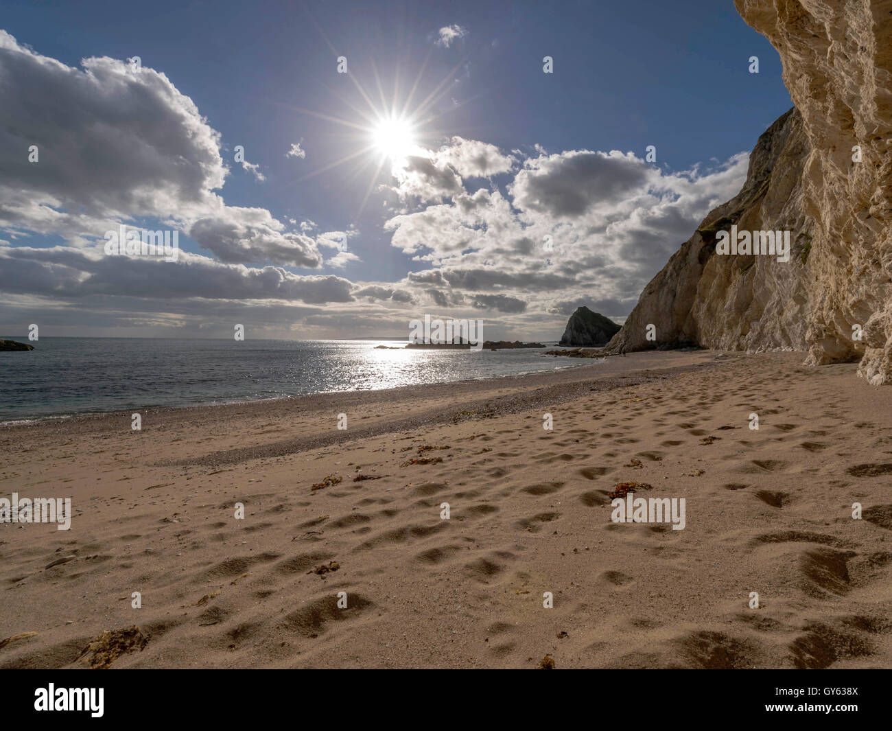 Landscape depicting the sandy shoreline at Man O'War beach on a fine summer day with Durdle Door headland in the background. Stock Photo