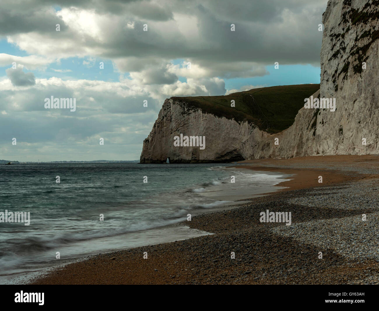 Landscape depicting the pebbled Jurassic shoreline on a fine summer day with Bat's Head in the background. Stock Photo