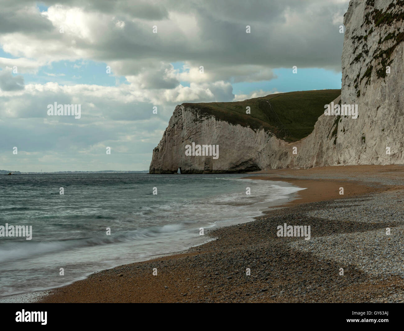 Landscape depicting the pebbled Jurassic shoreline on a fine summer day with Bat's Head in the background. Stock Photo