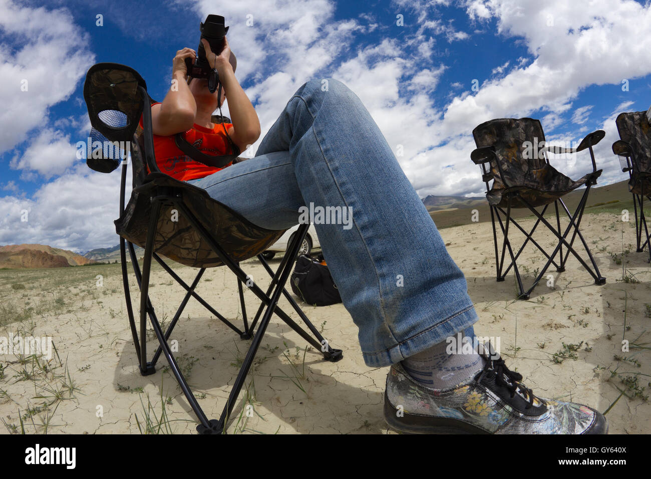 Portrait of young woman nature photographer taking landscape pictures in the desert area (Altai, Russia). Stock Photo