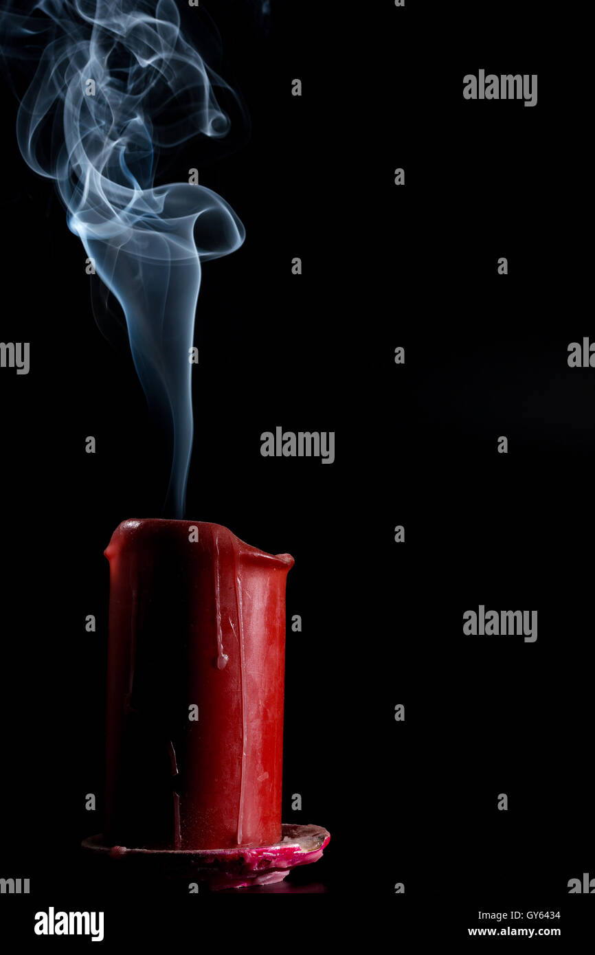extinguished the candle of red color on a black background Stock Photo