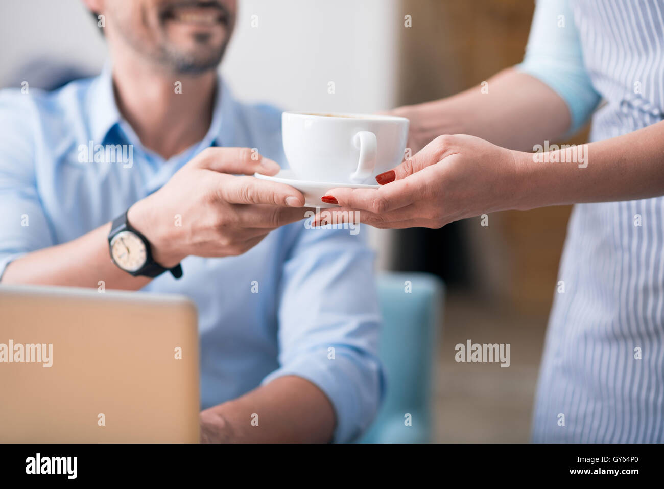 One female cafe worker giving coffee Stock Photo