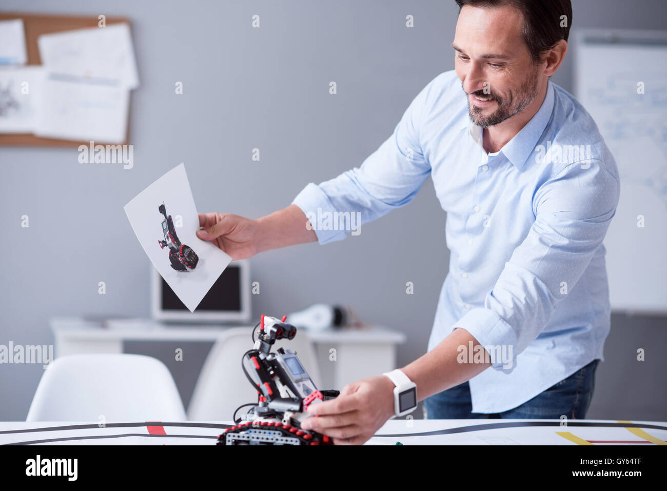 Happy scientist holding a prototype of his invention Stock Photo