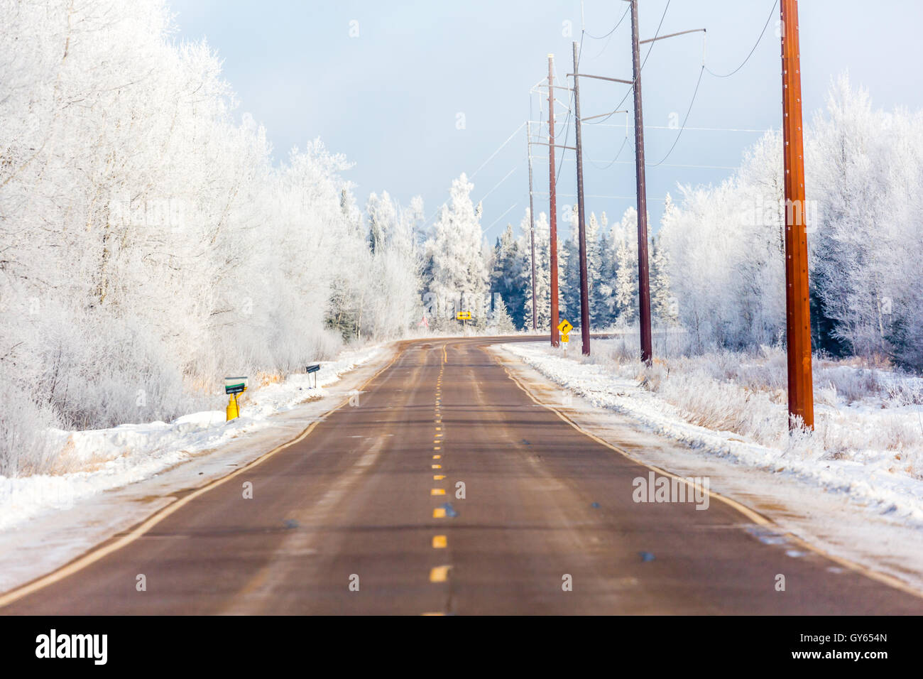 Highway going through a frost covered forest in Wisconsin. Stock Photo