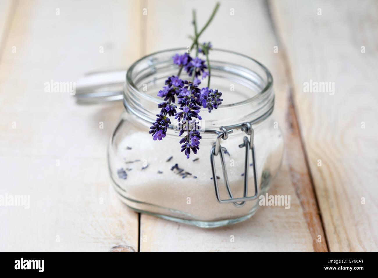 small bouquet of lavender on a jar of lavender sugar on a light wooden background Stock Photo