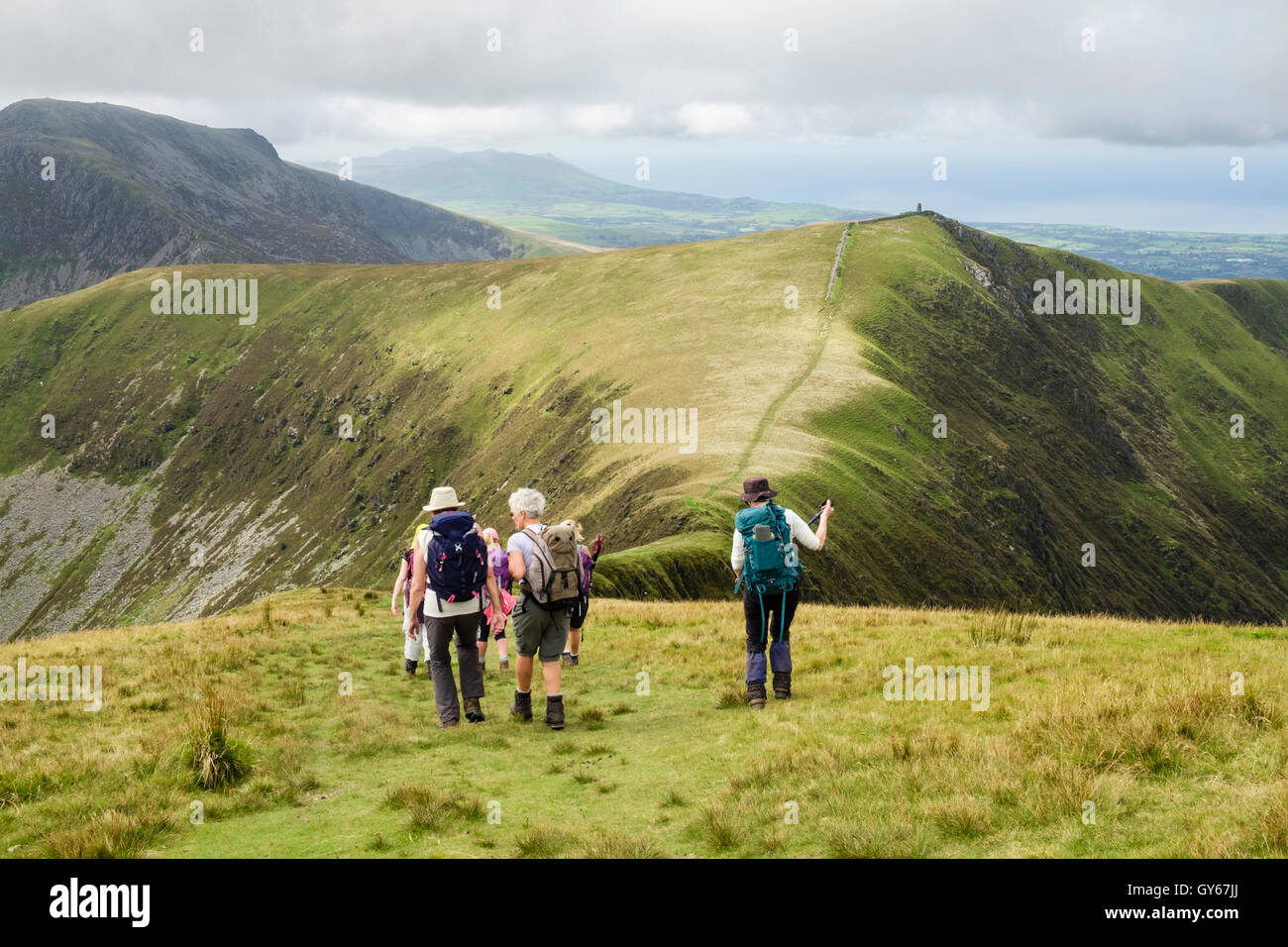 Hikers hiking west on path from Trum y Ddysgl to Mynydd Talymignedd