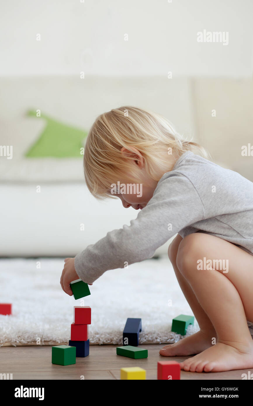 Toddler playing with wooden blocks Stock Photo - Alamy