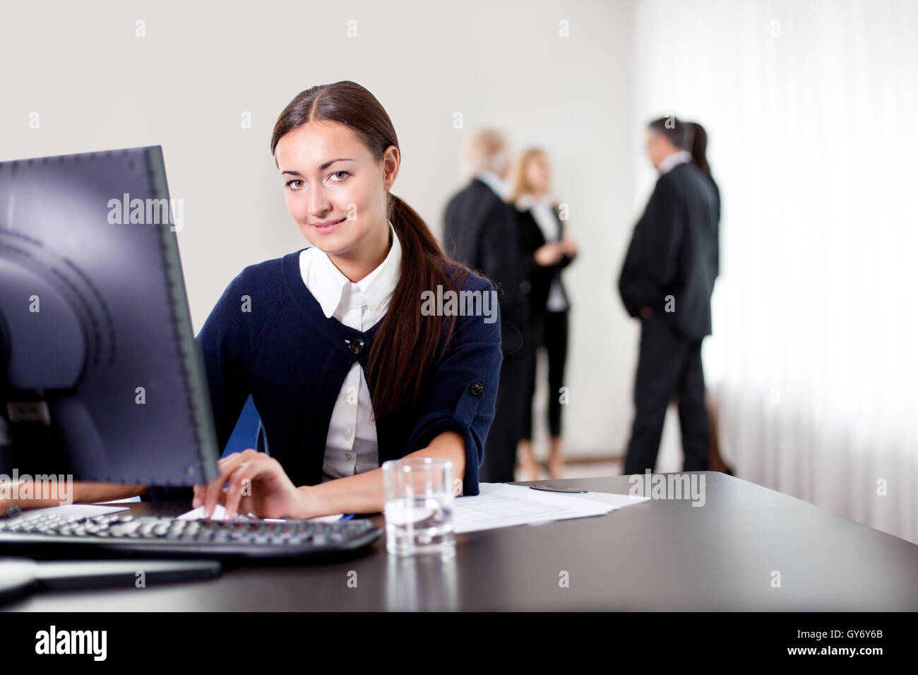 Smiling young business woman using computer Stock Photo - Alamy