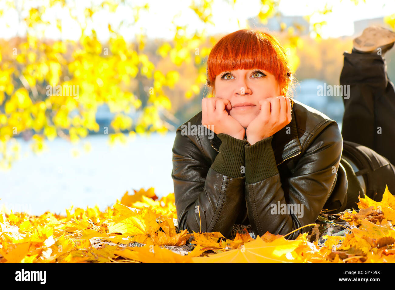 beautiful girl with red hair in leaves in autumn park Stock Photo - Alamy