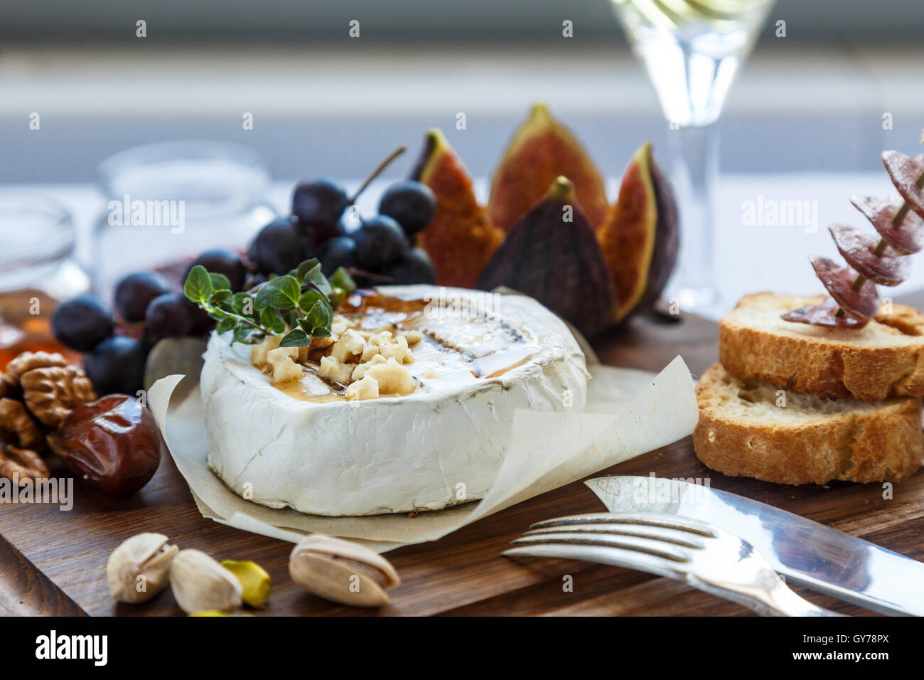 Baked camembert cheese with figs, honey, grapes and nuts. Top view