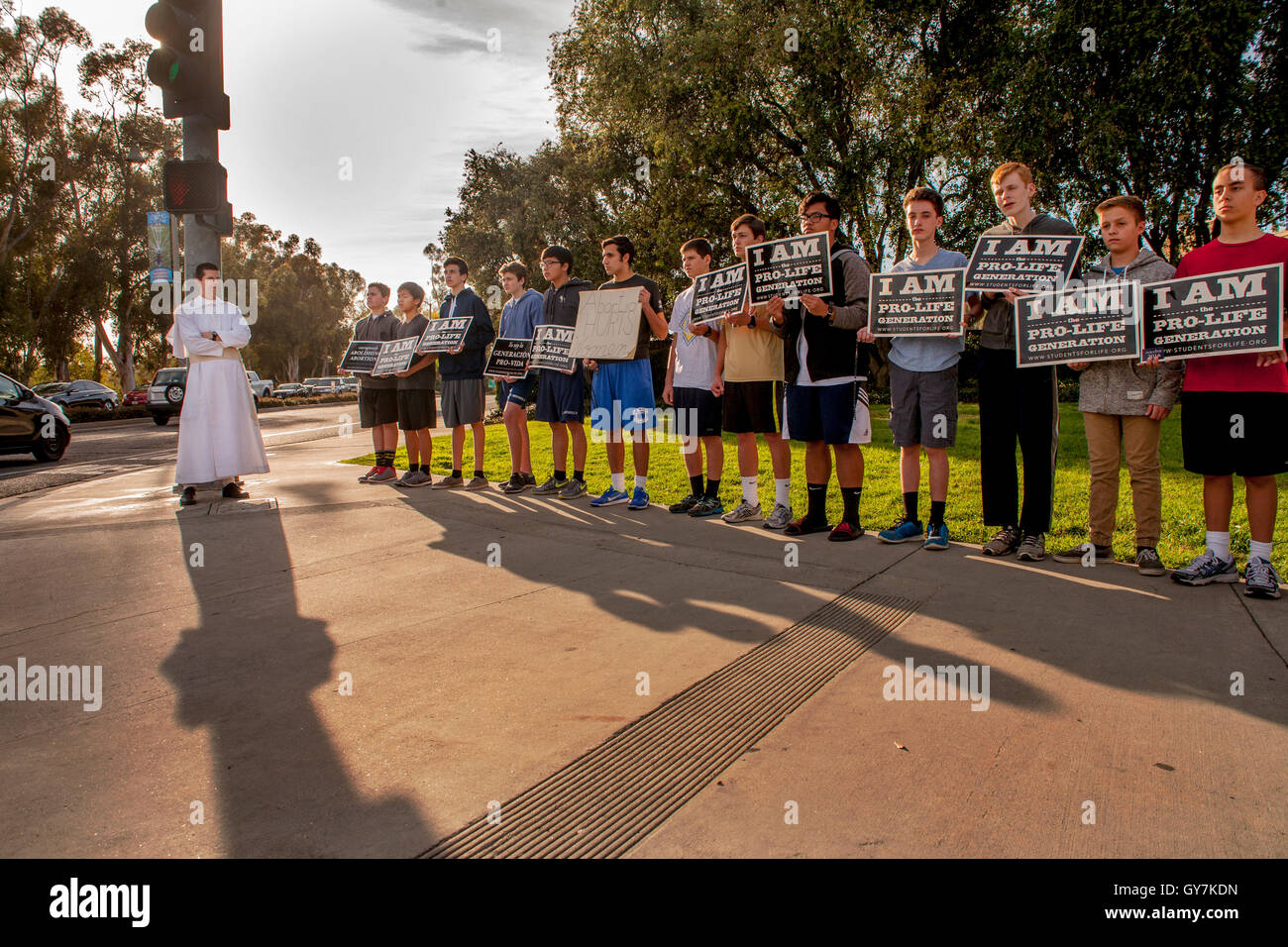 Accompanied by a priest, an all-male group of Catholic teen and boy protesters holds an anti abortion demonstration outside a branch of Planned Parenthood in Mission Viejo, CA. Note crucifix. Stock Photo