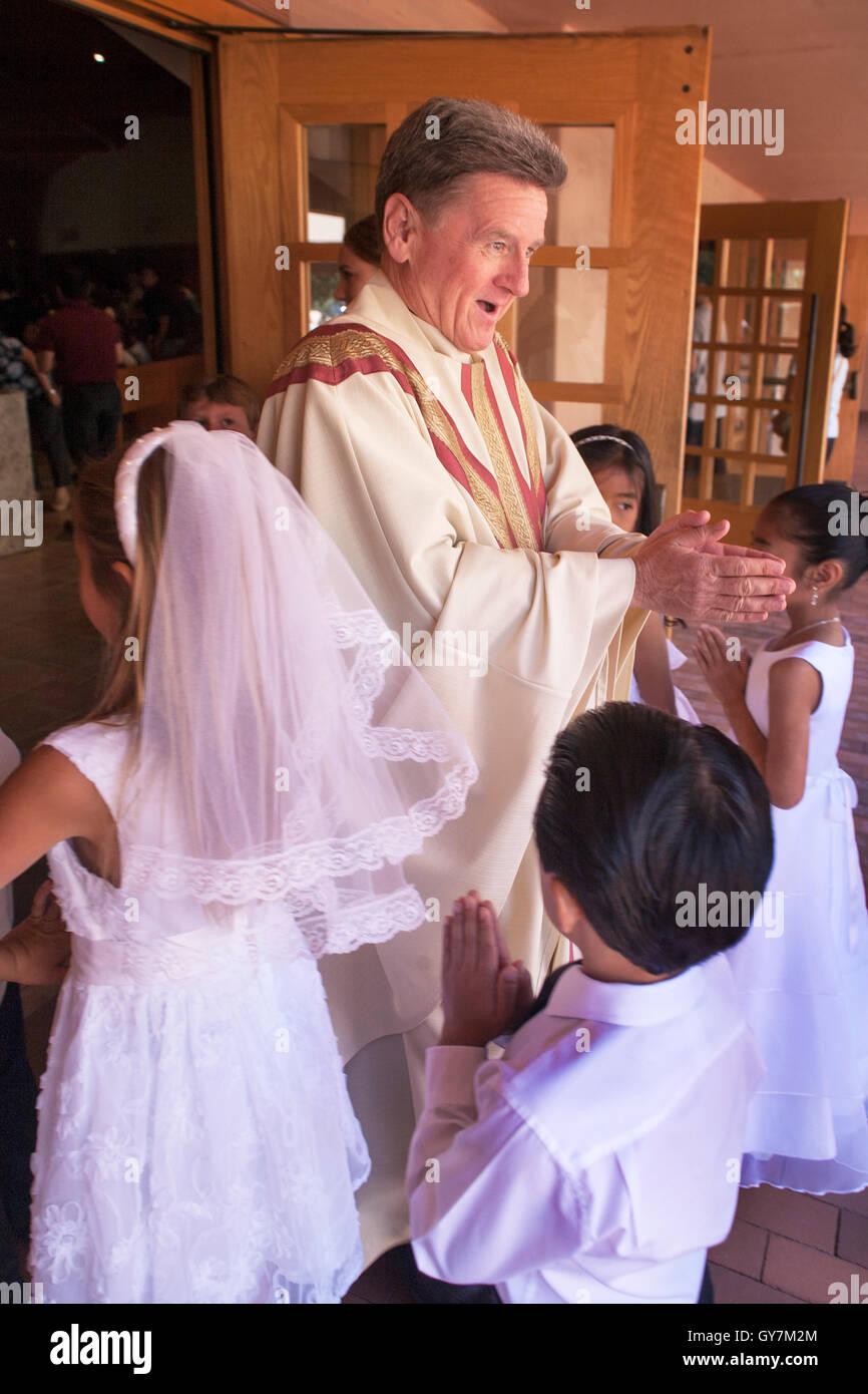 Formally dressed Hispanic and Caucasian children socialize with a ...