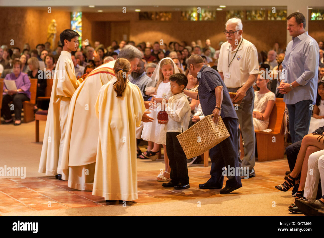 Church ushers bring the day's collection in baskets to the monsignor of a Laguna Niguel, CA