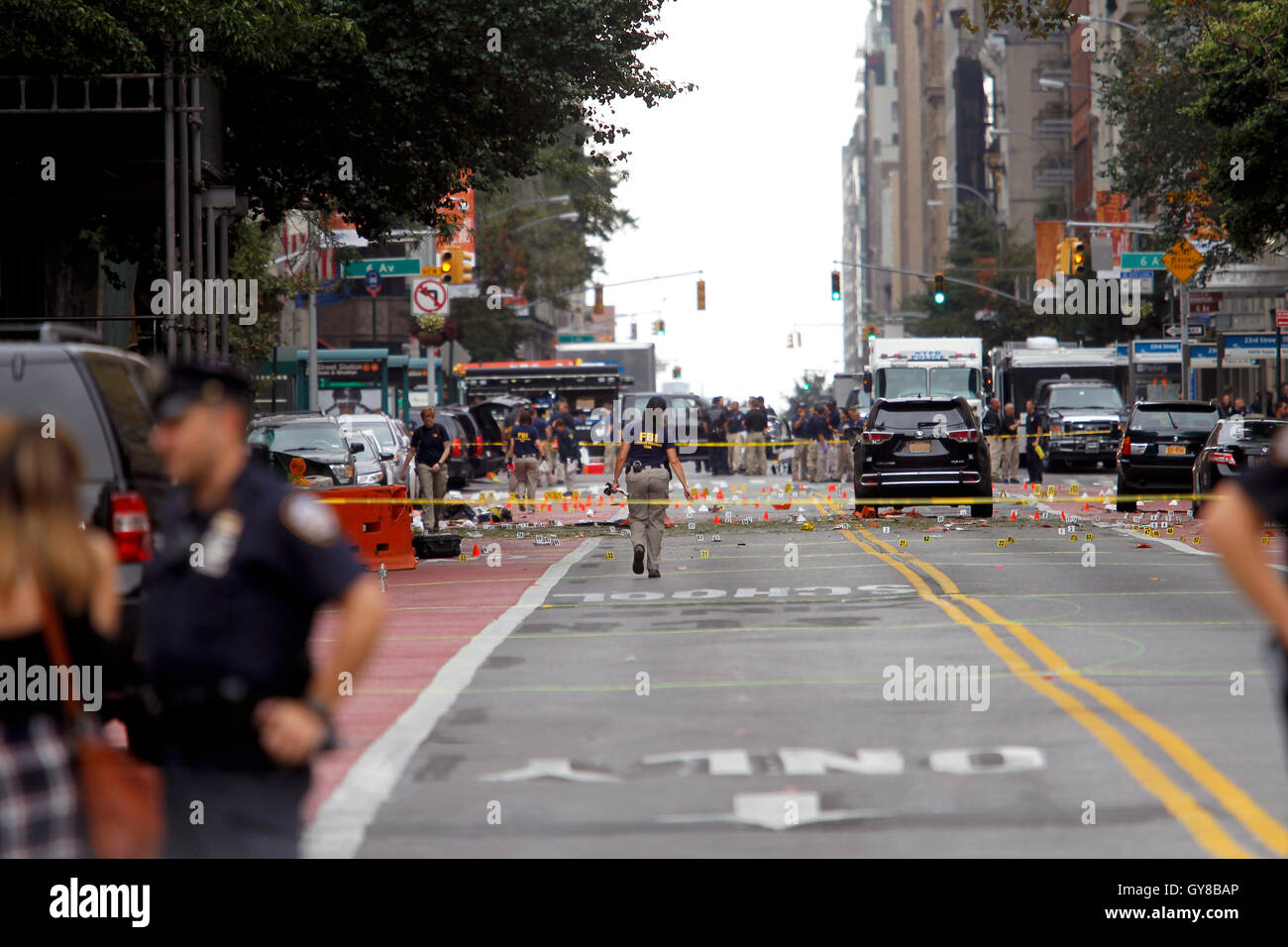 New York, USA. 18th Sep, 2016. Police, and law enforcement personnel from various agencies examine the area for clues the morning after last night's explosion on New York's West 23rd Street between 6th and 7th Avenues in the Chelsea section of Manhattan.  the view is looking east on 23rd street from 7th Avenue towards 6th Avenue.  The area is marked for clues amidst the debris.  29 people were injured in the blast which has been described by officials as intentional.  In the foreground police guard the street. Credit:  Adam Stoltman/Alamy Live News Stock Photo