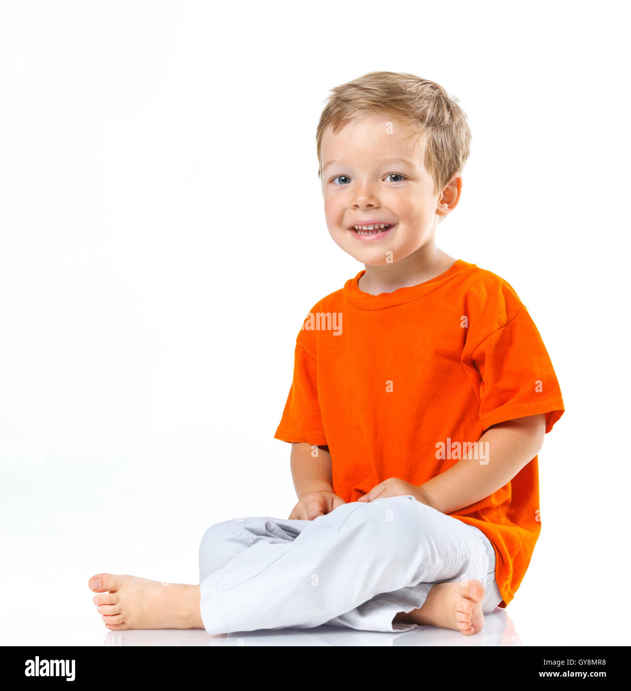 Happy boy sitting on the floor Stock Photo - Alamy