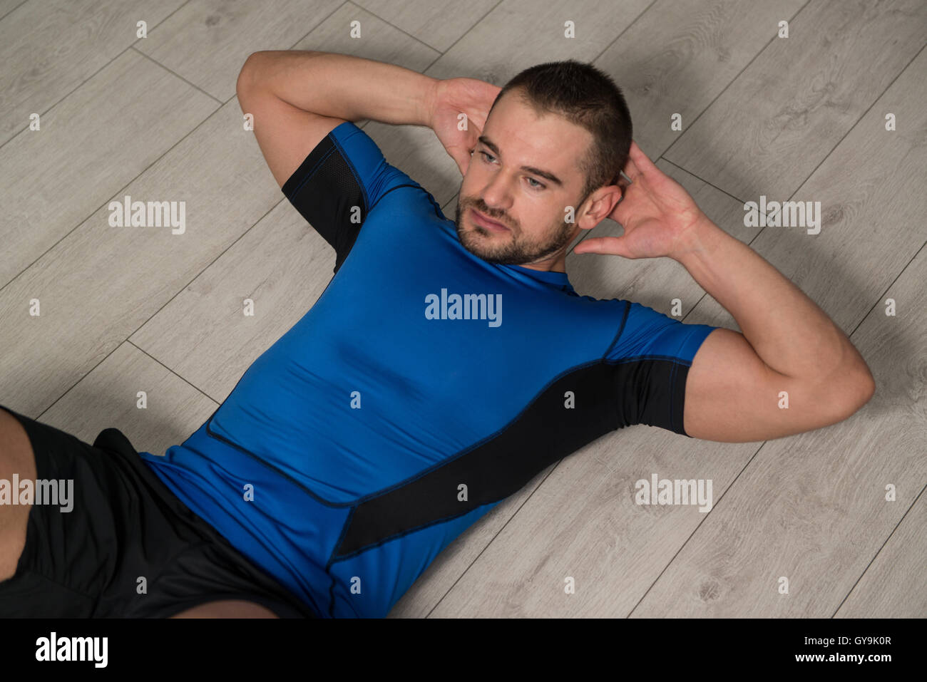 Personal Trainer Performing Abdominal Exercise On Floor One Of