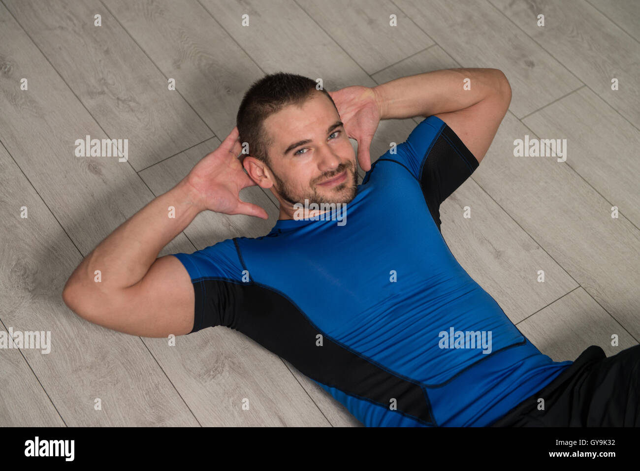 Personal Trainer Performing Abdominal Exercise On Floor One Of
