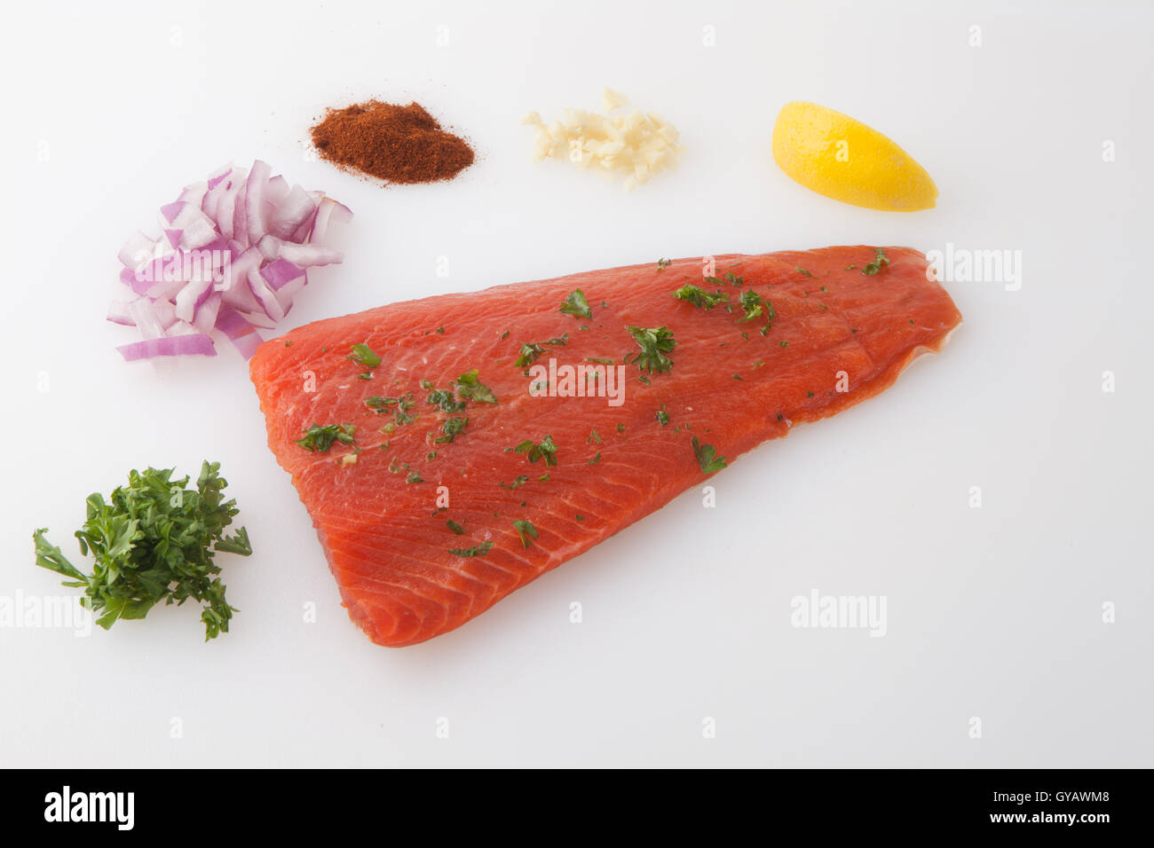 Sockeye Salmon uncooked placed on a white chopping board with seasoning Stock Photo