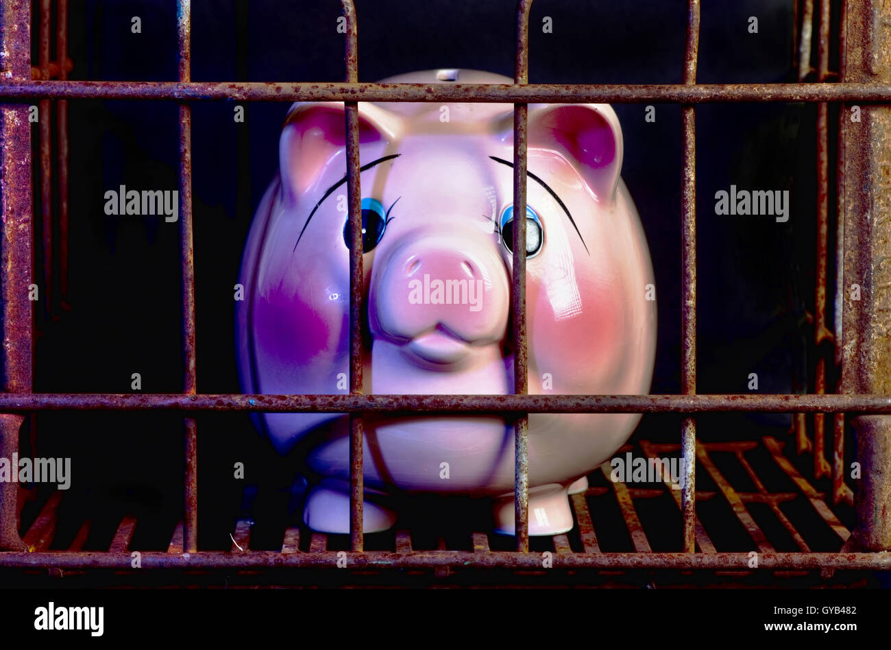 Pink piggy band in jail needing more money. Stock Photo