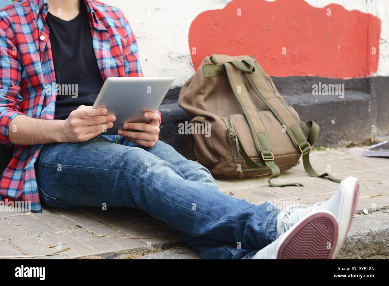 Young latin man using a tablet at the street. Stock Photo